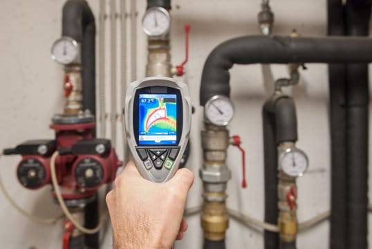 Plumber using a thermal imaging camera to inspect pipes in Gainesville